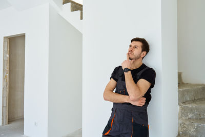 Young woman standing against wall