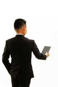 Rear view of man holding camera against white background