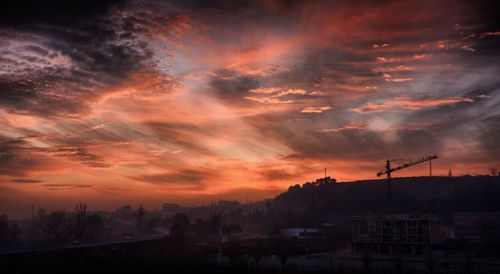 Silhouette city against sky during sunset