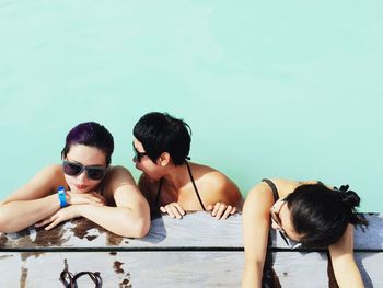 High angle view of friends in swimming pool on sunny day