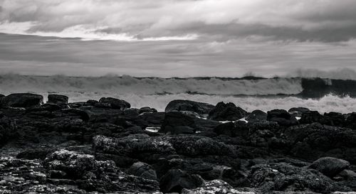 Rocks on sea shore against sky