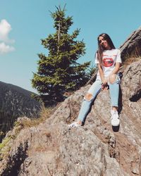 Portrait of happy young woman against trees