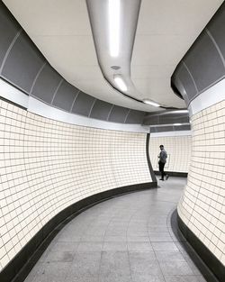 Rear view of man walking in corridor