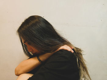 Portrait of woman against wall at home