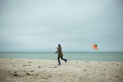 Man standing on beach against sky