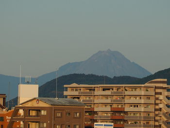 Buildings in city against clear sky