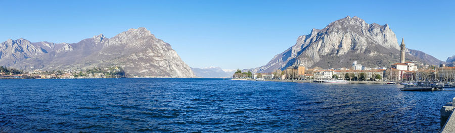 Panoramic view of sea and mountains against blue sky