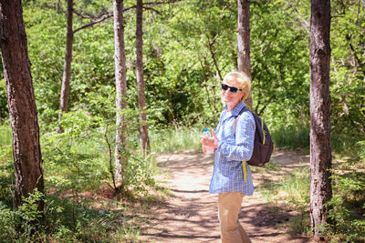 Portrait of young man standing in forest