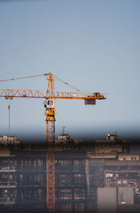 Low angle view of crane against clear sky