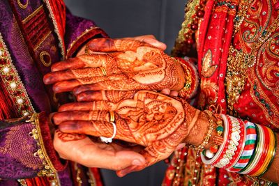 Midsection of couple holding hands during wedding ceremony