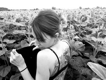 Rear view of woman standing amidst plants