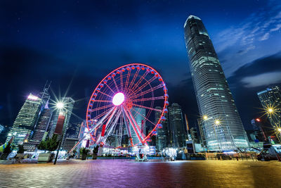 Illuminated ferris wheel against sky at night