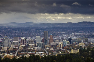 View of cityscape against cloudy sky