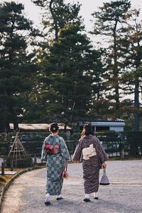 Rear view of people walking on sidewalk