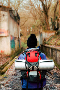 Unrecognizable backpacker trekking in autumn forest