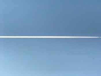 Vapor trail against clear blue sky