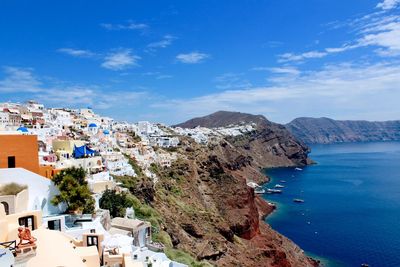 High angle view of town by sea against sky