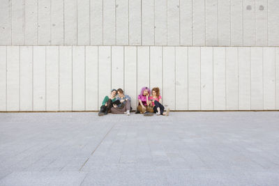 Portrait of friends standing against wall