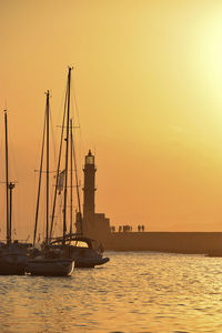 Sailboats sailing on sea against sky during sunset