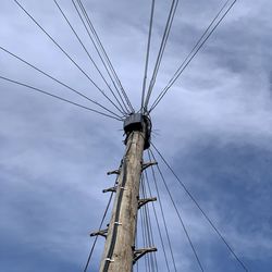 Low angle view of electricity pylon against sky