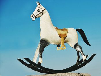 Low angle view of horse against clear blue sky