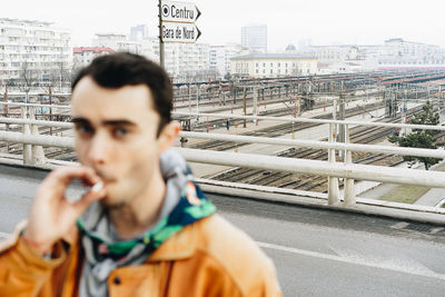 Portrait of man photographing with cityscape in background