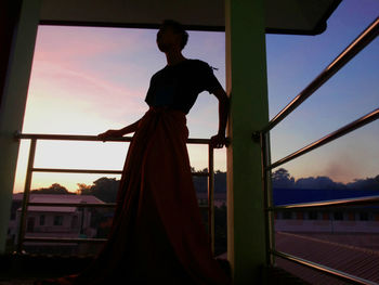 Low angle view of silhouette woman standing against sky during sunset