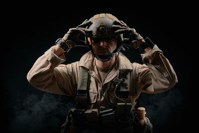 Man wearing helmet against black background