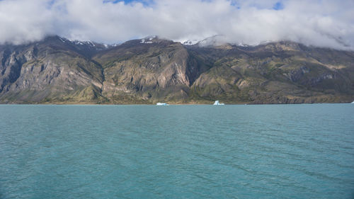 Scenic view of sea and mountains against sky