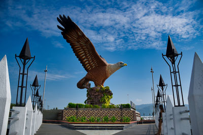 Low angle view of birds flying against blue sky