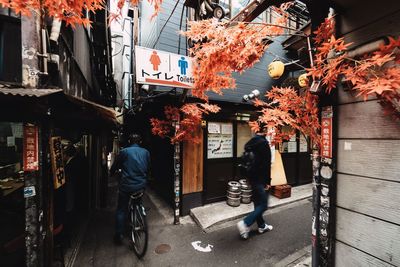 Rear view of people walking on street in city