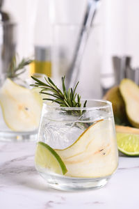 Gin cocktail with lime, rosemary, ripe pear and tonic. this organic drink 