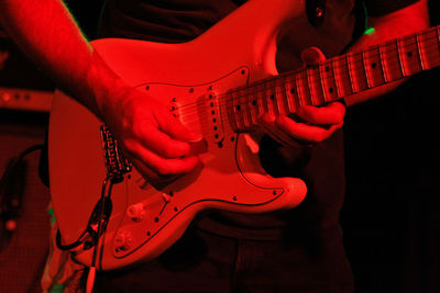 Midsection of man playing guitar