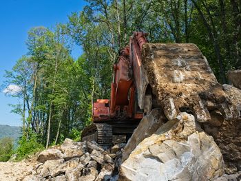 View of construction site by trees against sky