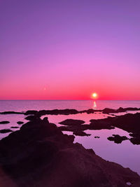 Scenic view of sea against romantic sky at sunset