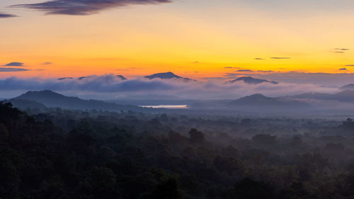 Scenic view of mountains against orange sky