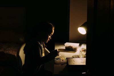 Rear view of boy sitting at home