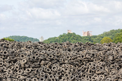 Stack of old metal structure against sky