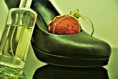 Close-up of perfume by shoe on table