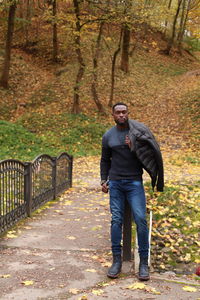 Full length portrait of man standing in park during autumn