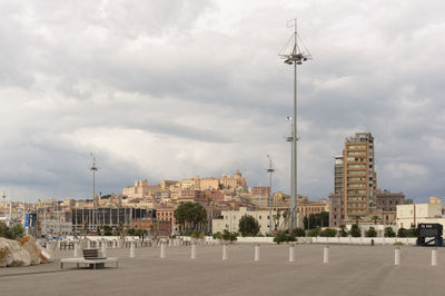 Buildings in city against cloudy sky