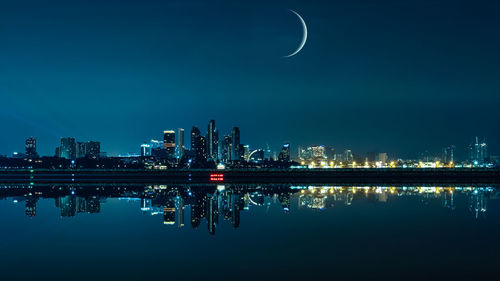 City scape at night the moon blue sky background reflection on the sea foreground in thailand