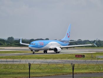 Airplane on runway against sky