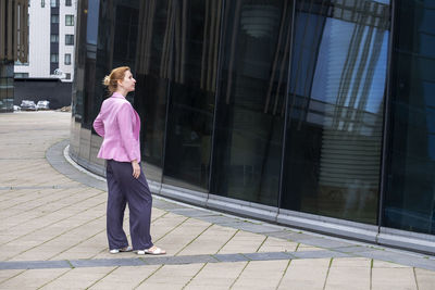 Full length of woman standing on street amidst buildings