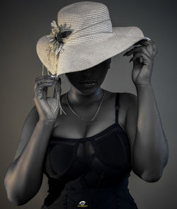 Young woman wearing hat against black background