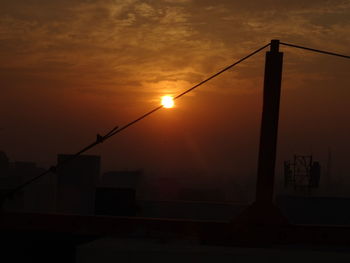 Silhouette street light against sky during sunset