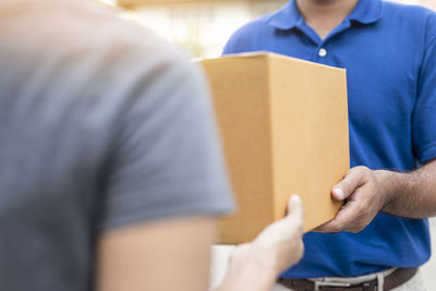 Midsection of man holding camera in box