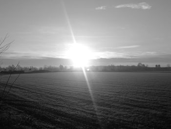 Scenic view of field against bright sun