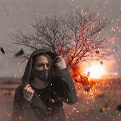 Portrait of woman by bare tree against sky during sunset