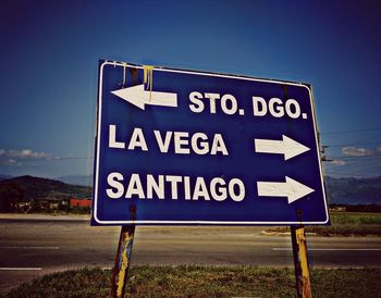 Information sign on road against sky